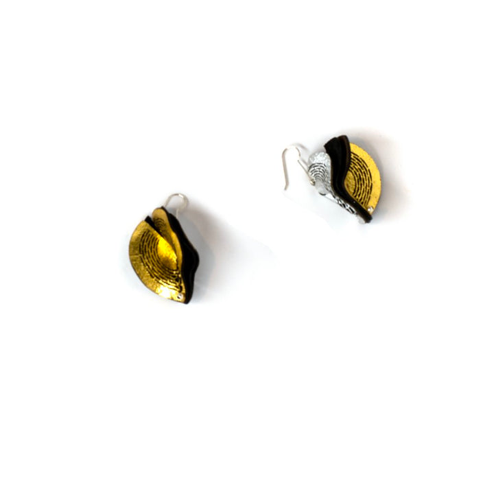 Gold and silver leaf-shaped earrings on a white background